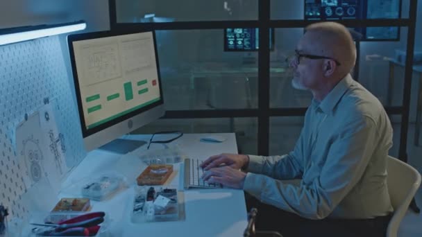 夜遅くにオフィスでコンピュータで作業する高齢の白人男性エレクトロニクスエンジニアのウエストアップ — ストック動画