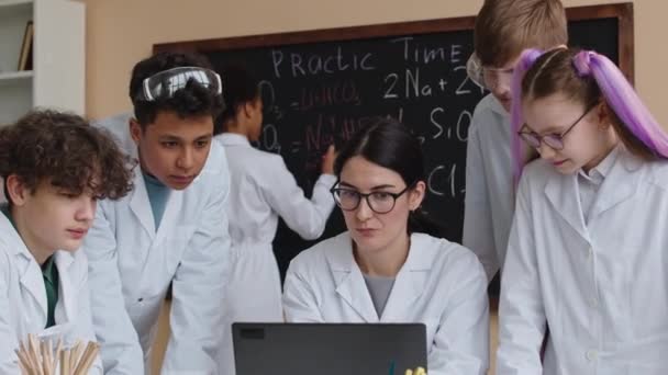 Średnie Ujęcie Młodej Białej Nauczycielki Chemii Dającej Lekcję Wieloetnicznym Dzieciom — Wideo stockowe