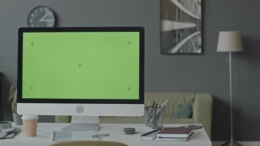 Ofisteki masaüstünde yeşil şablon ekranlı bilgisayar monitöründen çekilen kimse yok