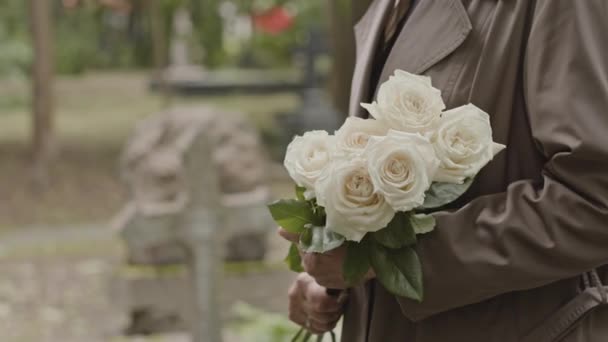 Beskuren Bild Oigenkännlig Kvinna Med Vita Blommor Står Vid Graven — Stockvideo