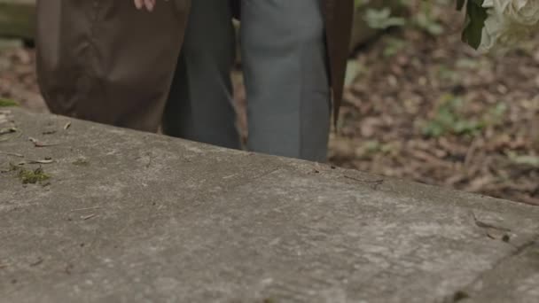 在冰冷的花岗岩墓碑上挂上无法辨认的哀伤寡妇的剪影 — 图库视频影像