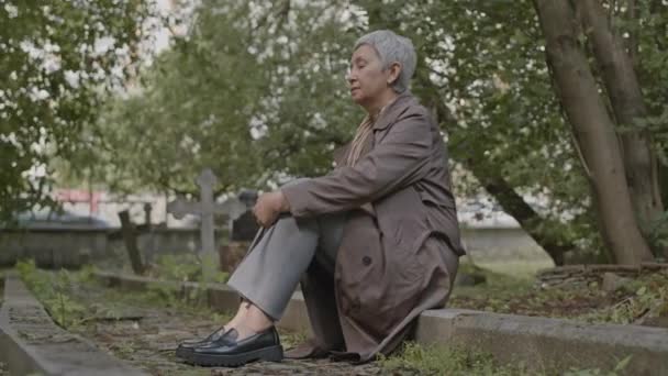 Grieving Mature Asian Woman Sitting Curb Cobblestone Graveyard Alley Cemetery — Stock Video