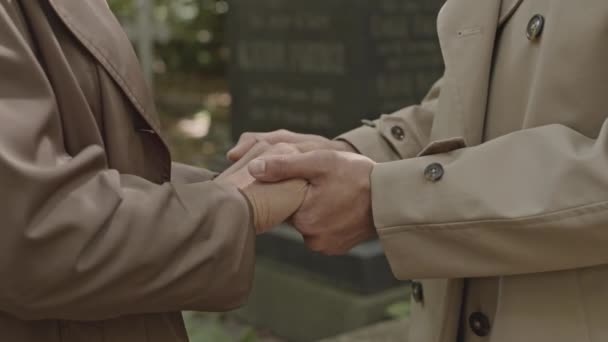Обрезанный Снимок Двух Неузнаваемых Людей Плащах Стоящих Держась Руки Поддерживая — стоковое видео