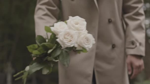 Przycięte Ujęcie Nierozpoznawalnego Mężczyzny Kładącego Bukiet Pięknych Białych Róż Zimnoszarym — Wideo stockowe