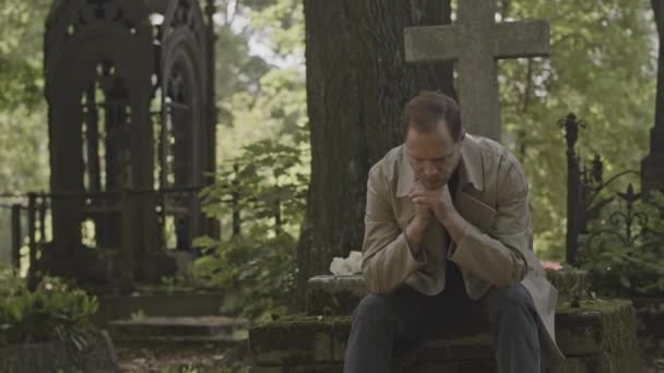 Colpo Medio Uomo Caucasico Lutto Trench Seduto Con Mani Preghiera — Video Stock