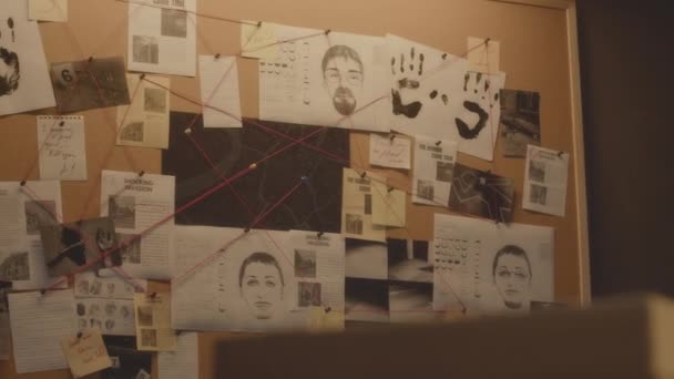 容疑者の手札やスケッチ 新聞のクリッピングで捜査委員会を撮影した人はいない 空の探偵事務所の壁に赤い糸で絡み合った — ストック動画