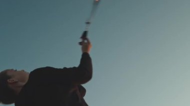 Beyaz kızın yaz festivali sırasında gün batımında ateşle hokkabazlık yaptığı düşük açılı çekim.