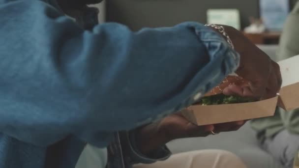 Tilt Van Vrolijke Jonge Afro Amerikaanse Man Eten Heerlijke Hamburger — Stockvideo