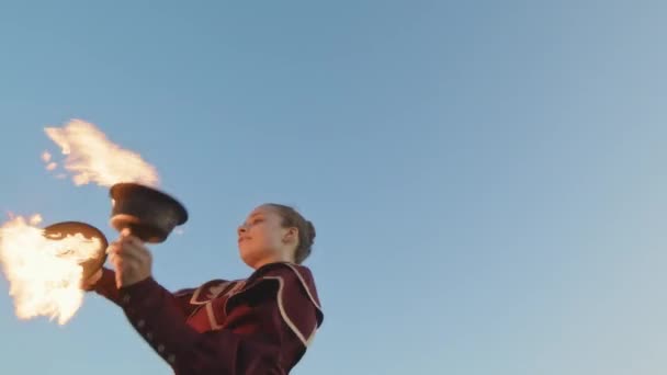 勇敢なコーカサス女の子の低い角度は 夕方に青の下で2つの燃える鉄の火の弓で踊っています — ストック動画