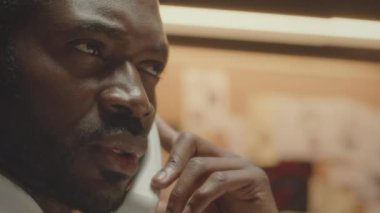 Ciddi bir Afro-Amerikan FBI ajanının iş yerindeki sabit hat telefonuyla orta boy görüntüsü.