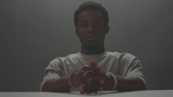 Oddálit Portrét Zatčeného Černocha Který Frustrovaně Dívá Kameru Sedící Stolem — Stock video
