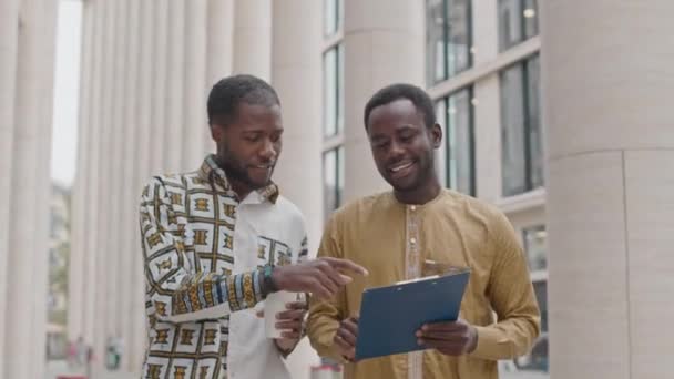 Средний Снимок Двух Молодых Афроамериканских Коллег Мужчин Просматривающих Деловые Документы — стоковое видео