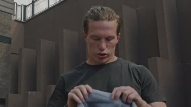 Açık havada yorucu bir kardiyo çalışması yaptıktan sonra terini havluyla silen beyaz bir erkek göğsü.