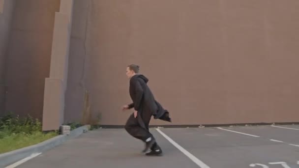 Siyah Elbiseli Beyaz Bir Adamın Duvardan Tırmanırken Sokakta Park Numaralarını — Stok video