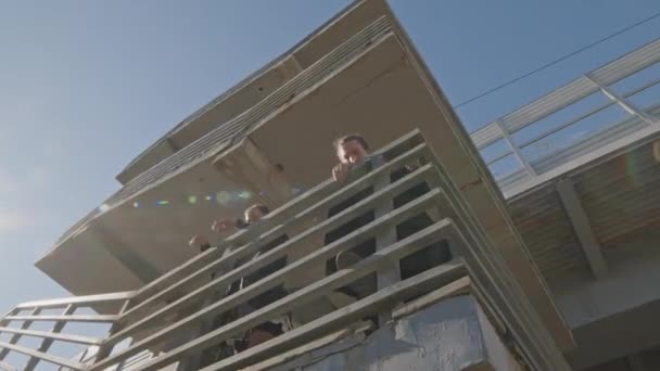 一緒に建設現場の柵から飛び降りるパルクールアーティストの低角度ショット — ストック動画