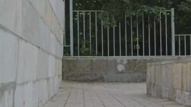 Aktif beyaz kadın gündüz vakti sanayi bölgesinde park ve duvar tırmanışı yapıyor.
