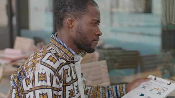 Två Unga Afroamerikanska Manliga Kollegor Diskuterar Marknadsföringsstatistik Medan Sitter Vid — Stockvideo