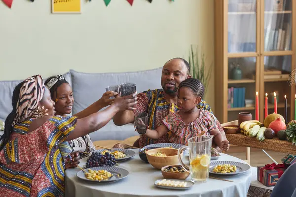 Familia Africana Trajes Nacionales Tostadas Con Bebidas Sentadas Mesa Comedor —  Fotos de Stock