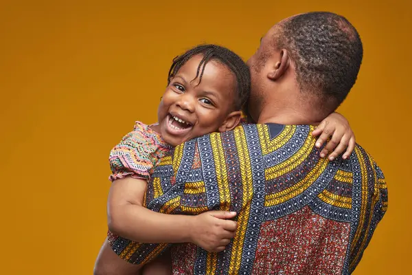 Africana Niña Feliz Sonriendo Cámara Mientras Abraza Padre Sobre Fondo —  Fotos de Stock