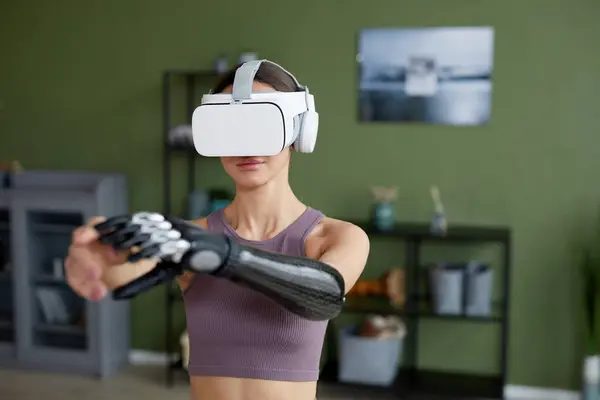 穿着虚拟现实眼镜的年轻女子在家里的房间里接受训练 — 图库照片
