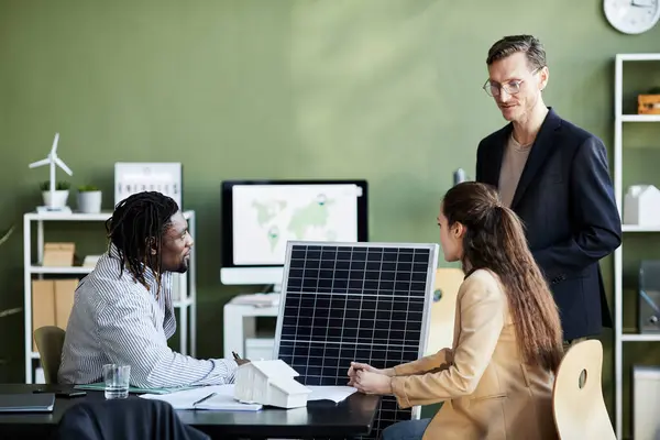 一些商界人士在办公室开会时坐在桌旁 开发太阳能电池板作为替代能源 — 图库照片