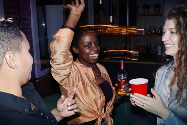 Grupa Wesołych Międzykulturowych Dziewcząt Luźnych Strojach Pijących Drinki Tańczących Przed — Zdjęcie stockowe