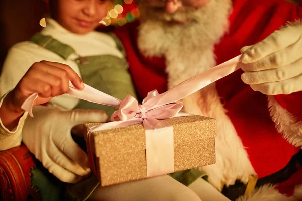 Закрыть Маленькую Девочку Открывающую Рождественский Подарок Сидя Коленях Сантаса Скопировать — стоковое фото