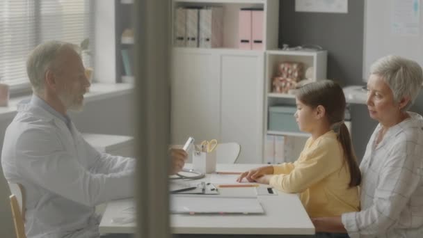 Beyaz Labaratuvar Önlüğü Giyen Beyaz Erkek Çocuk Doktorunun Büyükannesinin Muayenehanesinde — Stok video