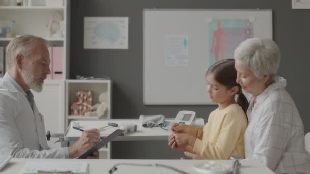 병원에서 소아과 의사를 방문하는 온도계를 보유하고 말하는 아시아 여성의 — 비디오
