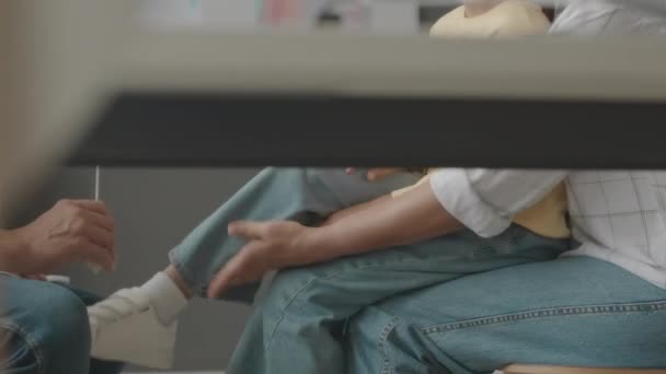 一名无法辨认的男性神经科医生在医院接受检查时 在撞倒小女孩膝盖时被人用铁锤砸伤 — 图库视频影像
