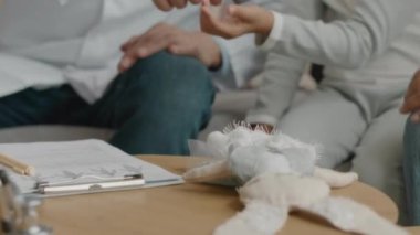 Hasta sıcaklığını ölçmek için temas kurulamayan kızılötesi termometre kullanan tanınmayan bir erkek doktorun görüntüsü ve ev muayenesi sırasında tıbbi belgelere not almak.
