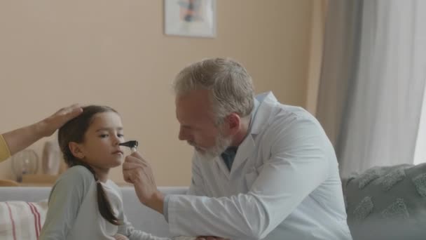 Талия Белого Врача Средних Лет Осматривающего Нос Азиатской Маленькой Больной — стоковое видео