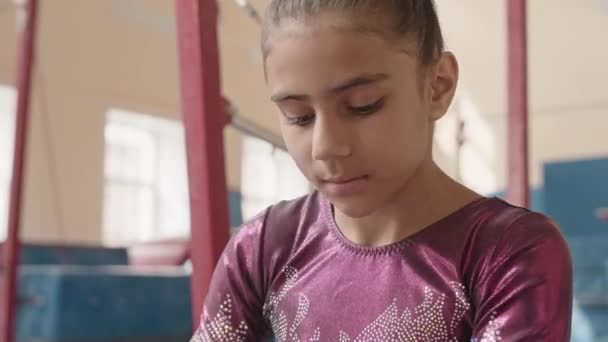 Elementary Age Biracial Gymnast Girl Sitting Beam Wearing Buckle Grips — Stock Video