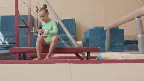 Kaukasisches Mädchen Grundschulalter Sitzt Auf Einer Bank Und Trägt Schnallengriffe — Stockvideo