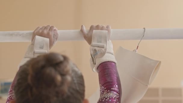 Widok Tyłu Małej Gimnastyczki Noszącej Klamry Opaskami Pocierającymi Proszek Kredą — Wideo stockowe