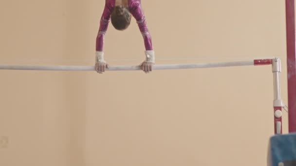 Визначена Маленька Дівчинка Фіолетовому Леопарді Обертається Гімнастичному Барі Практикуючи Художні — стокове відео