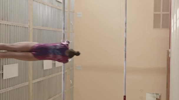 Вертикальний Повнометражний Знімок Талановитої Маленької Дівчинки Гімнастки Крутиться Гімнастичному Барі — стокове відео