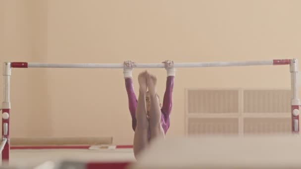 演播室里穿着紫色紧身衣的杂技表演小女孩在酒吧里做硬硬的艺术体操 — 图库视频影像