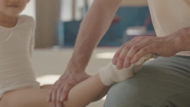 Entraîneur Professionnel Gymnastique Masculine Étirant Les Jambes Une Fille Asiatique — Video