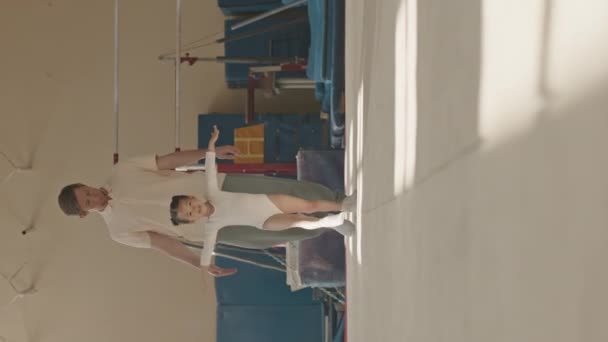 Vertikální Celovečerní Záběr Běru Bělocha Trenér Pomáhá Malé Gymnastka Dívka — Stock video