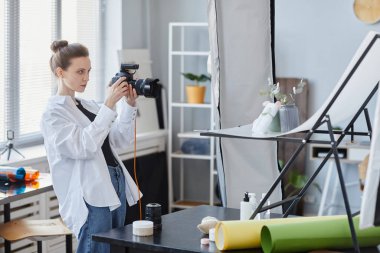 Stüdyoda ürün çeken profesyonel fotoğrafçı kadın portresi