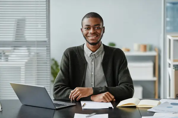 Front view portrait of young black man smiling at camera in job interview