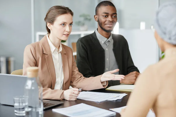 Minimal portrait of young business woman talking to candidate in job interview