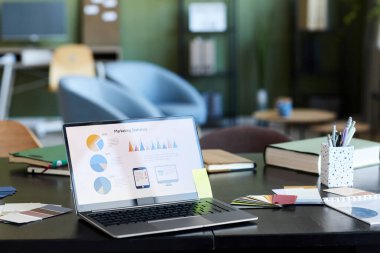 Ekonomist ya da ofisteki diğer beyaz yakalı işçilerin işyerindeki ekranda yer alan finansal şemaları ve diğer verileri içeren dizüstü bilgisayar