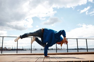 Breakdance amuda kalkarken çekilen çekim açık havada gökyüzüne poz veriyor, boşluğu kopyala