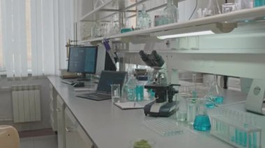 Hiçbir insan mikroskop görüntüsü yok, çeşitli cam parçaları tanımlanamayan sıvılar ve masaüstü bilgisayarıyla dolu. Profesyonel bilim adamının laboratuardaki çalışma masasında.