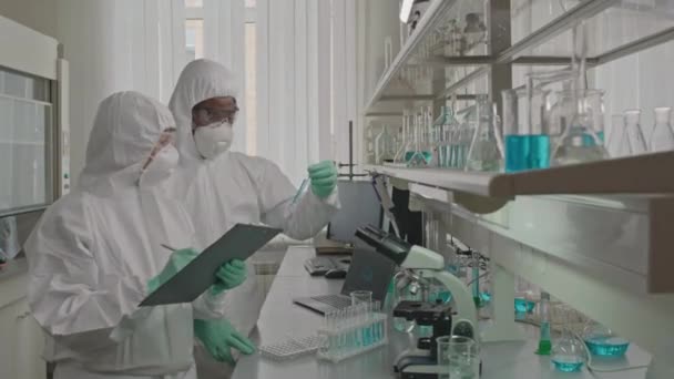 Plan Moyen Deux Biotechnologues Professionnels Vêtements Protection Vérifiant Les Éprouvettes — Video