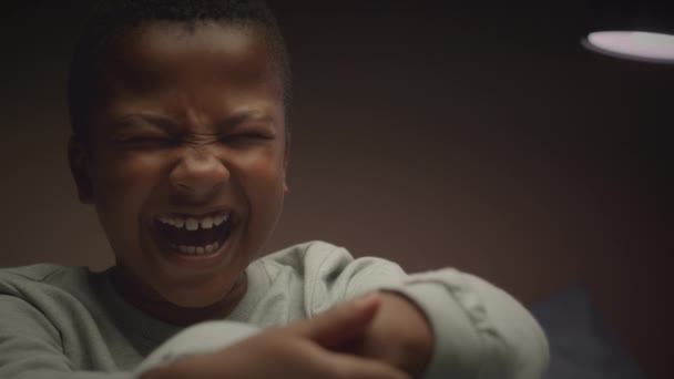 惊慌失措的非洲裔美国小男孩在昏暗的房间里从噩梦中大声尖叫 闪烁着中等的特写 — 图库视频影像