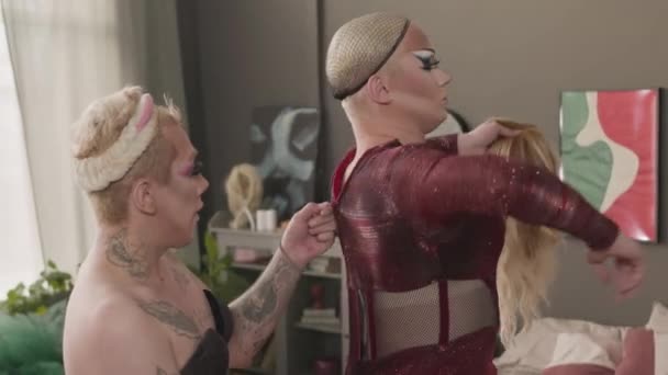 집에서 드래그 준비하는 단단한 빛나는 드레스를 고정하는 친구를 코카서스 동성애자 — 비디오