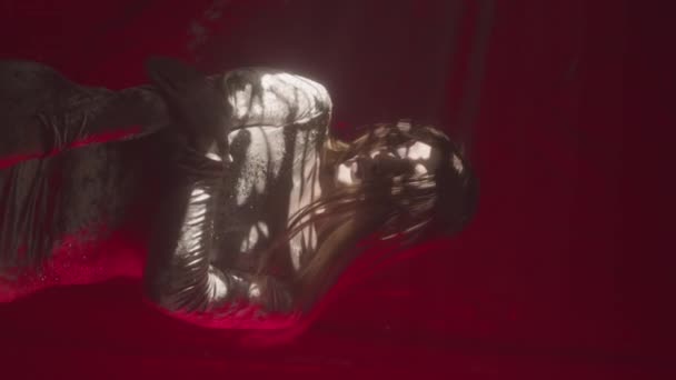 深色房间里穿着亮晶晶迷你裙的迷人的拖曳女王的垂直媒体画像 在红色背景下摆出相机的姿势 — 图库视频影像